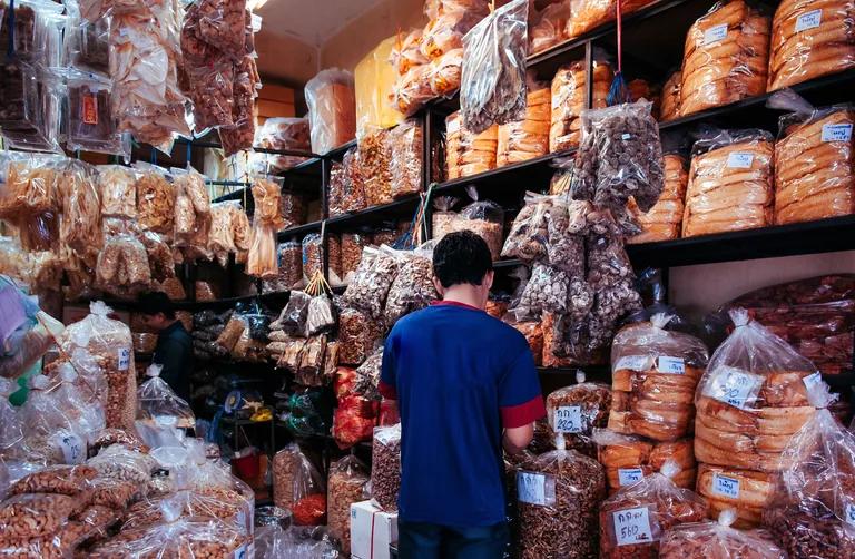 Shopper browsing packaged food and snacks at Kim Yong Market